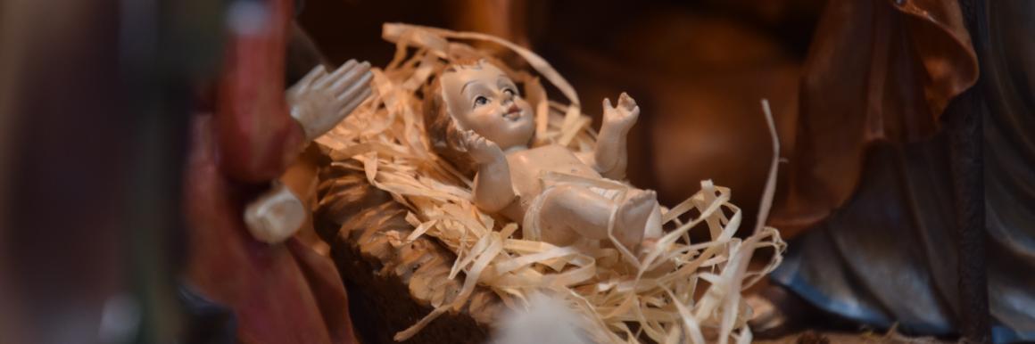 Close up of baby Jesus in a small nativity manger 