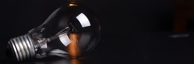 Light bulb on table in a dark room