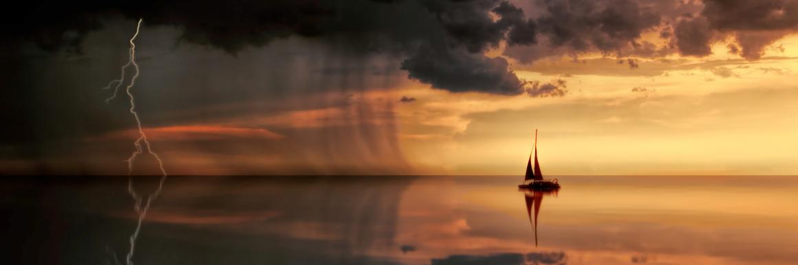 A sailboat on a yellow horizon at dusk with dark rain clouds on the left and lightening striking the water