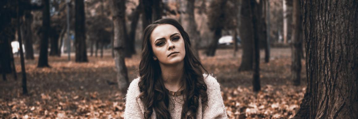 Woman sitting in the forest looking annoyed image link to story