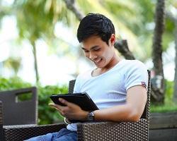 Young man reading on a tablet.
