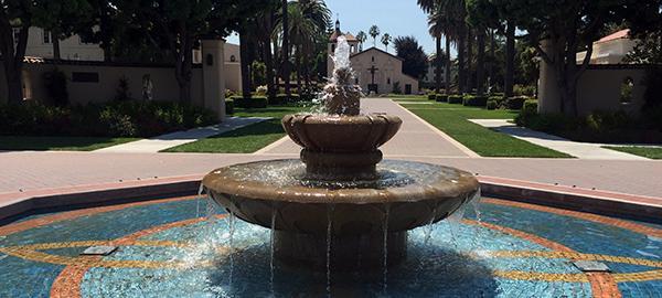 Fountain at the center of campus with Mission Santa Clara in the background.