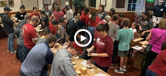 A group of people assembling meals for the homeless.