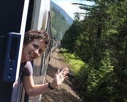 Woman waving out a train car window.