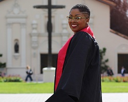 Black woman in SCU commencement robes.