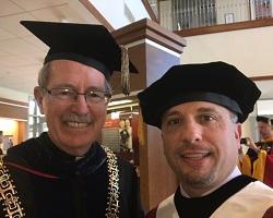 Fr. Michael Engh and John Torrey in commencement robes.