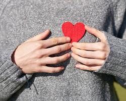 Person holding a felt heart against their chest.