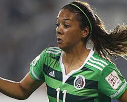 Maria Sanchez playing soccer in green and black jersey.