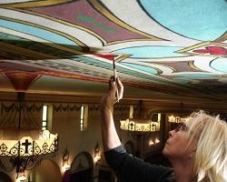 Woman painting the ceiling of Mission Santa Clara.