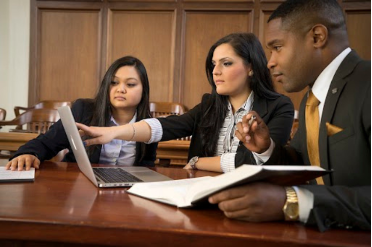 Three Law students in a courtroom.
