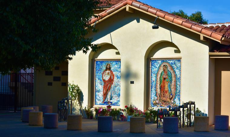 These mosaics of Jesus and Mary are surrounded by flowers and stone chairs to sit on. The mosaics are located at the back of the Sacred Heart of Jesus Catholic Church in the Washington-Guadalupe neighborhood of San Jose. [Photo by Elizabeth Drescher, 2020.]