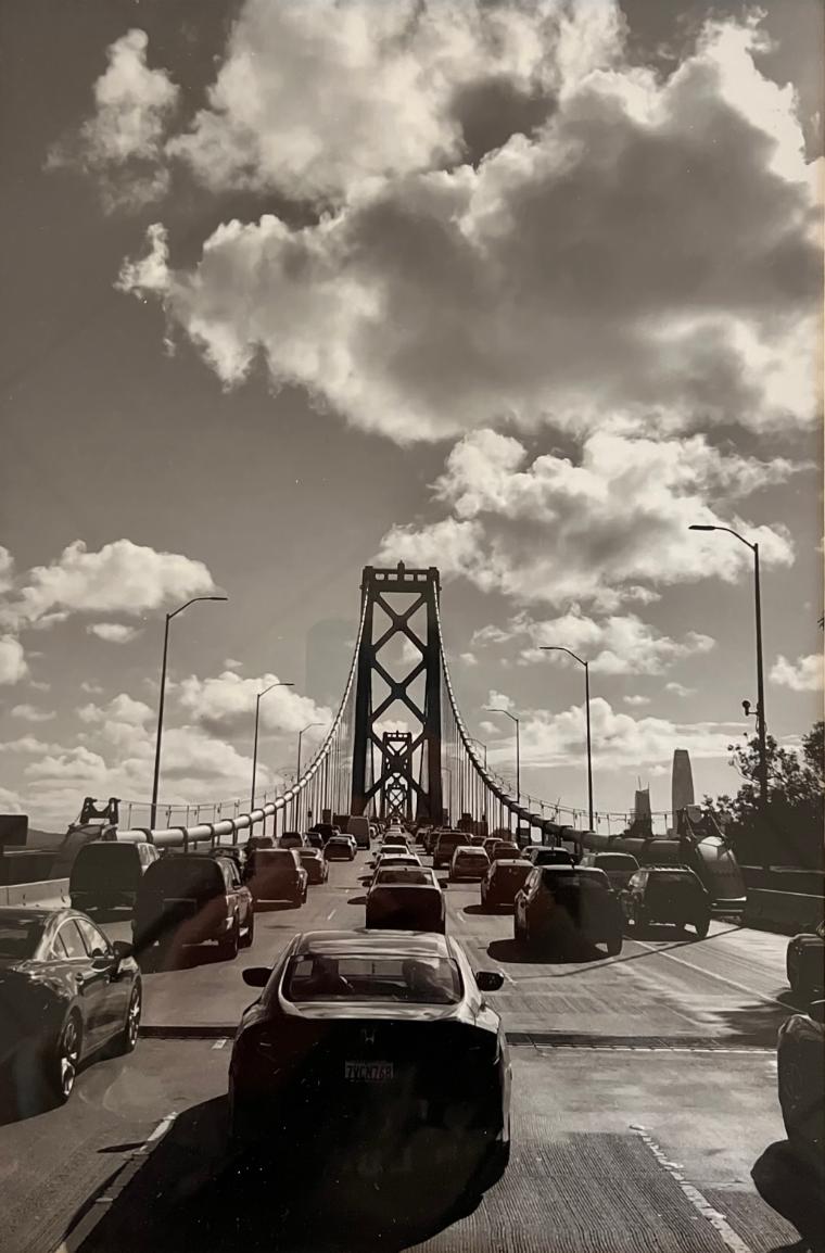Black and white photo of the Bay Bridge with a dramatic sky.