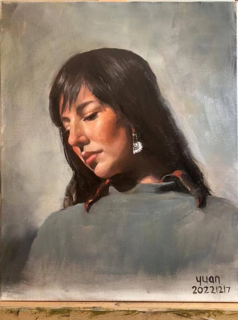 Portrait of a person looking downward against a textured background.