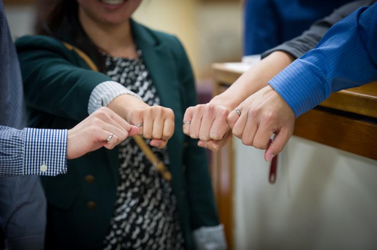 A photo of four hands showing off their new Order of the Engineer rings