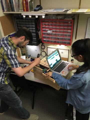 Prof. Navid Shaghaghi and Liying Liang working on assembling sensors in a hive box. image link to story