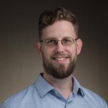 A person wearing glasses and a blue shirt, titled 