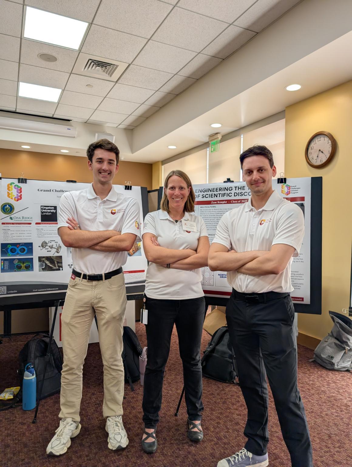 Two students and a faculty advisor are attending a poster session, where the students can present on their research projects.
