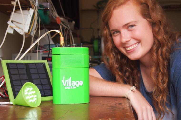 Rachel Wilmoth with the prototype of her 3D printed enclosure for Village Solar's solar panel, battery, and control electronics