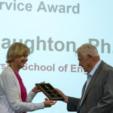 Dean Elaine Scott handing award plaque to Dr. Kennet Haughton image link to story