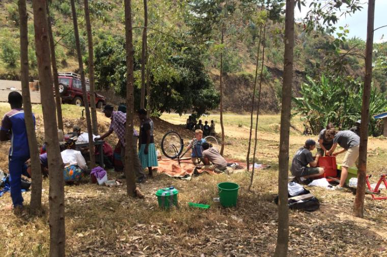 Field work: Following days of delays, SCU EWB students hustle to get their tile press  and bicycle-driven clay mixer up and running for the tile-making cooperative in Rwanda. image link to story