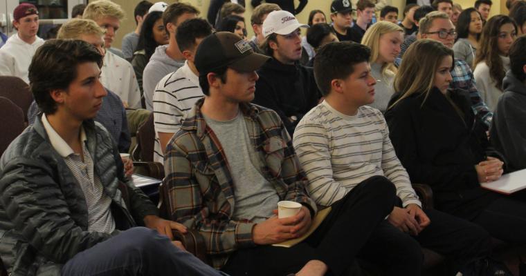 Students sitting and listening to speakers.