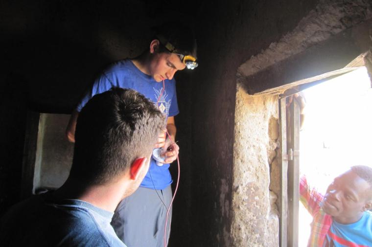 Nico Metais and Jacob Leatherberry install the first light bulbs in Alafiarou.