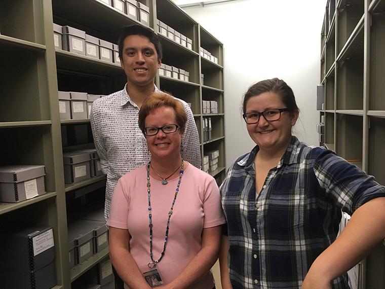 Michelle Runyon and Daniel Morales flank University archivist Erin Louthen in the SCU Archives. image link to story
