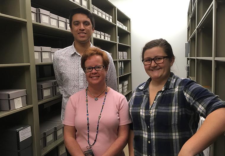 Michelle Runyon and Daniel Morales flank University archivist Erin Louthen in the SCU Archives. image link to story