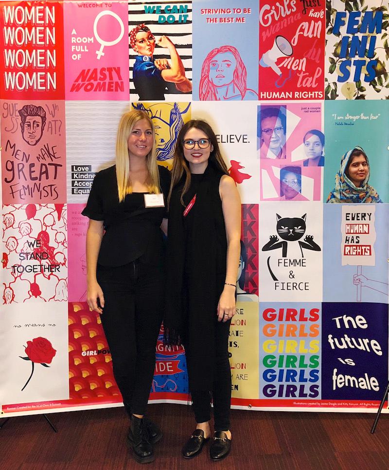 Jaime Daigle and Kitty Kenyon in front of the 2018 Own It conference mural.