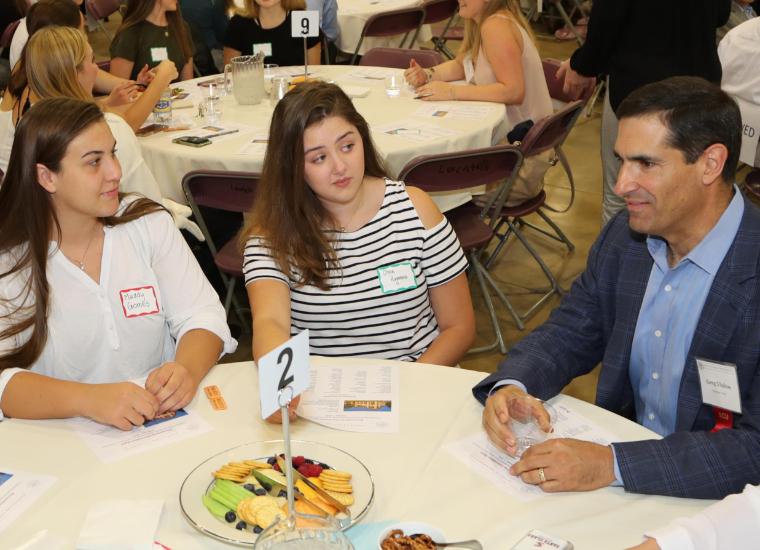 Alumni Greg Vlahos sitting with students at Accounting Information Night image link to story