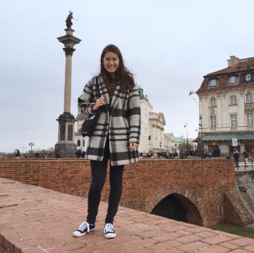 Emma on top of the castle wall in front of Sigismund III column in Warsaw. image link to story