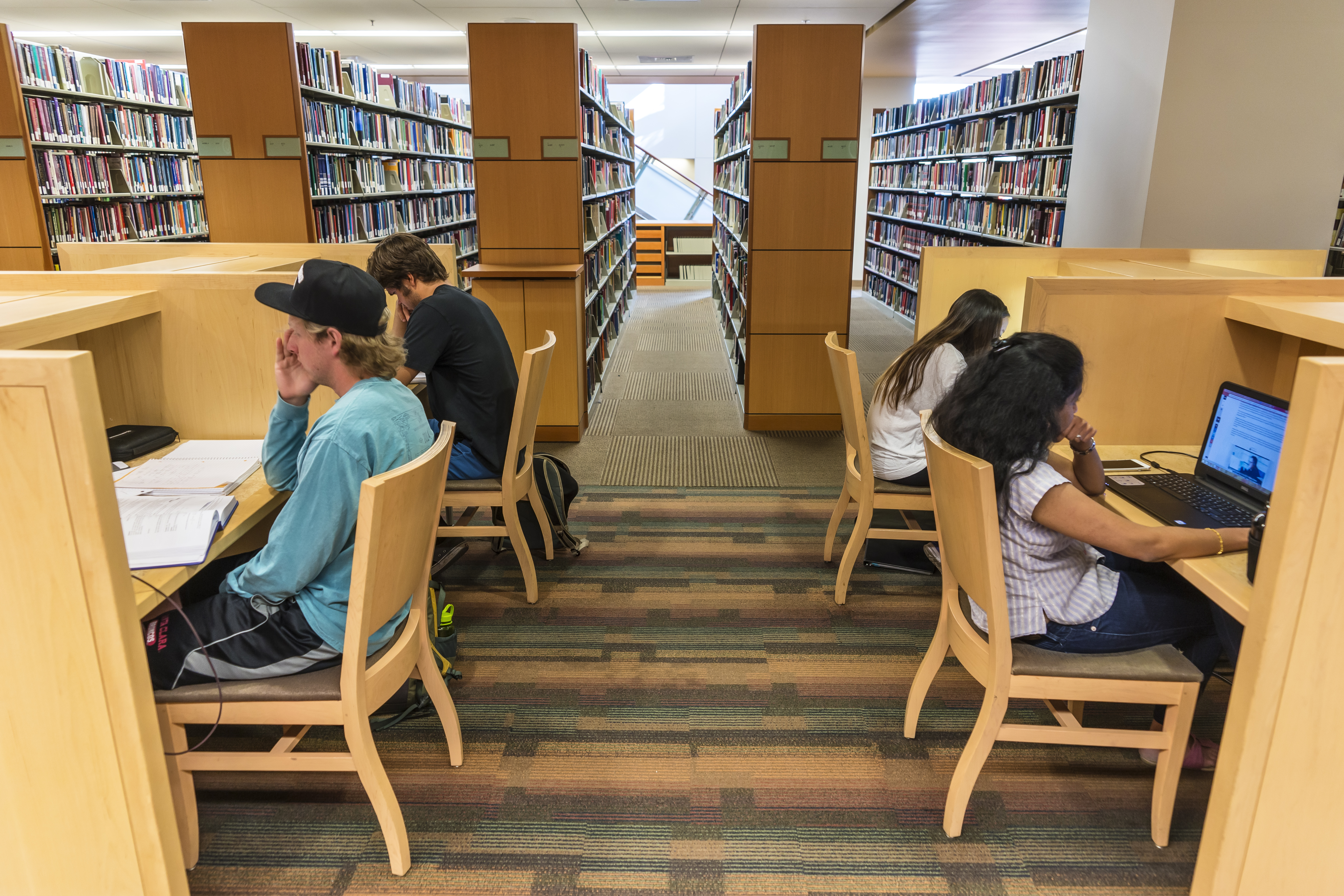 Four students studying on the lower level of the library